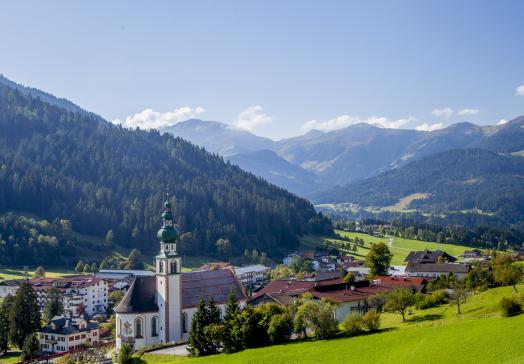 Aussenansicht Tirolerhof - im Vodergrund Pfarrkirche Oberau