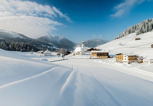 Snow-covered mountain village of Thierbach in the Wildschönau region of Tyrol, with church and winter landscape in the Kitzbühel Alps near the Landhotel Tirolerhof Oberau
