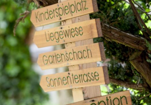 Wegweiser zu Garten, Liegewiese, Sonnenterrasse und Stadlbar im Landhotel Tirolerhof in Oberau in der Wildschönau