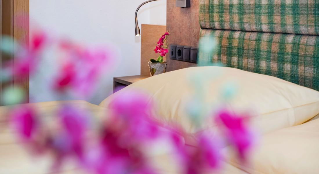 Detailaufnahme des Doppelbetts im Komfortzimmer Deluxe Abendsonne im Landhotel Tirolerhof in Oberau in der Wildschönau