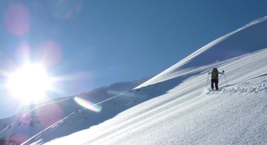 Person beim Skitourengehen in der Wildschönau in Tirol auf verschneitem Berghang mit Sonnenschein und Winterlandschaft nahe Landhotel Tirolerhof Oberau