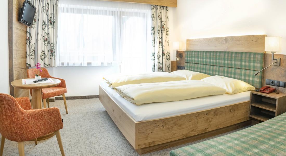 Komfortzimmer im Landhotel Tirolerhof in Oberau in der Wildschönau mit Doppelbett, Sitzecke und Balkon