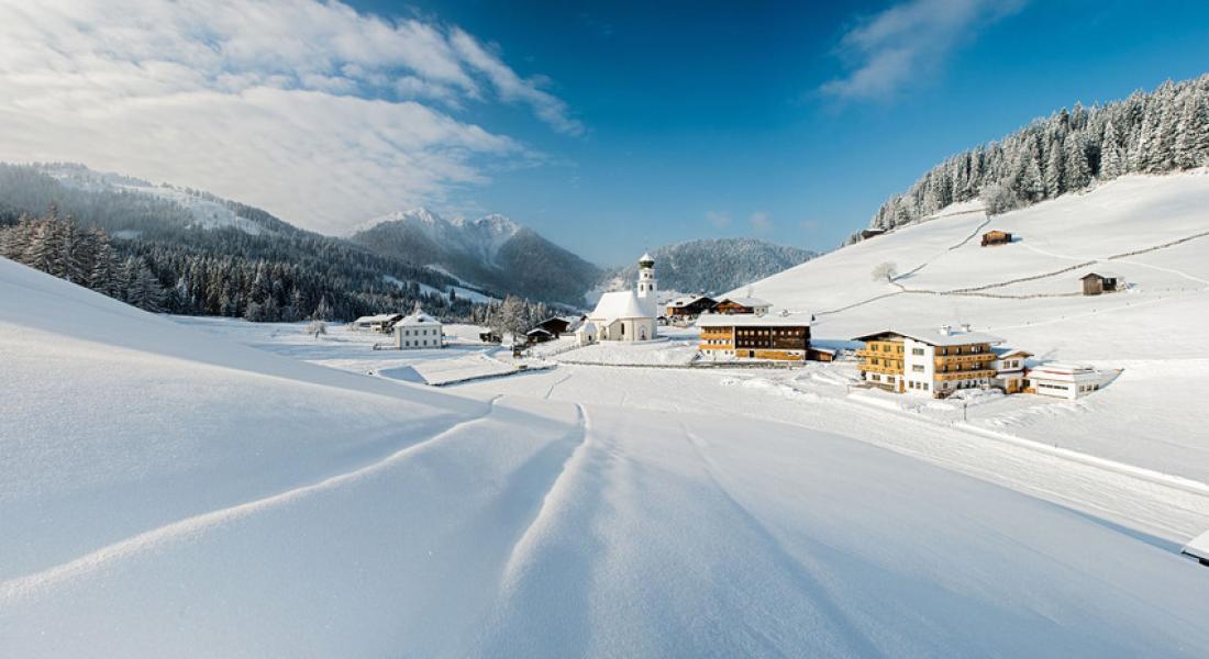 Snow-covered mountain village of Thierbach in the Wildschönau region of Tyrol, with church and winter landscape in the Kitzbühel Alps near the Landhotel Tirolerhof Oberau