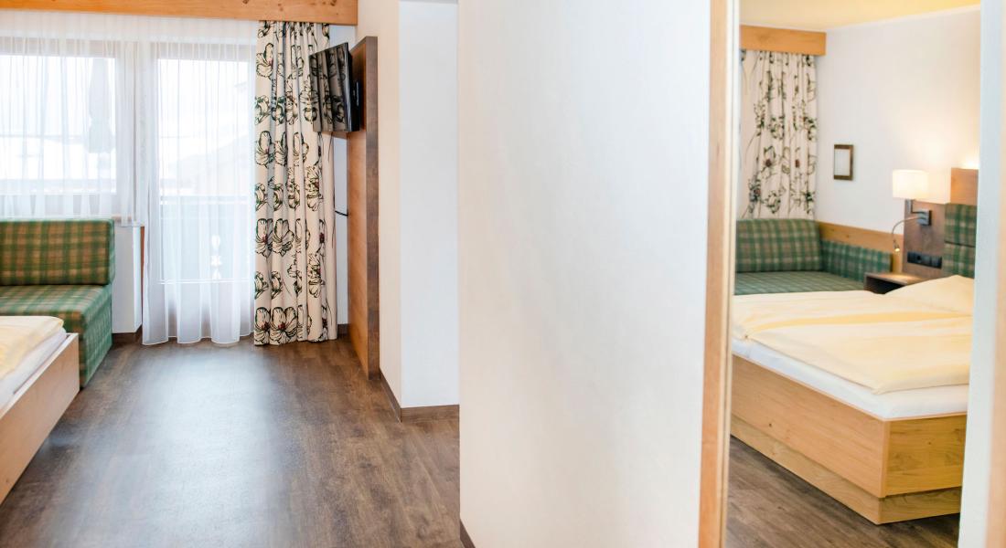 Wohnbereich mit Sofa und TV im Komfortzimmer Deluxe Abendsonne im Landhotel Tirolerhof in Oberau in der Wildschönau