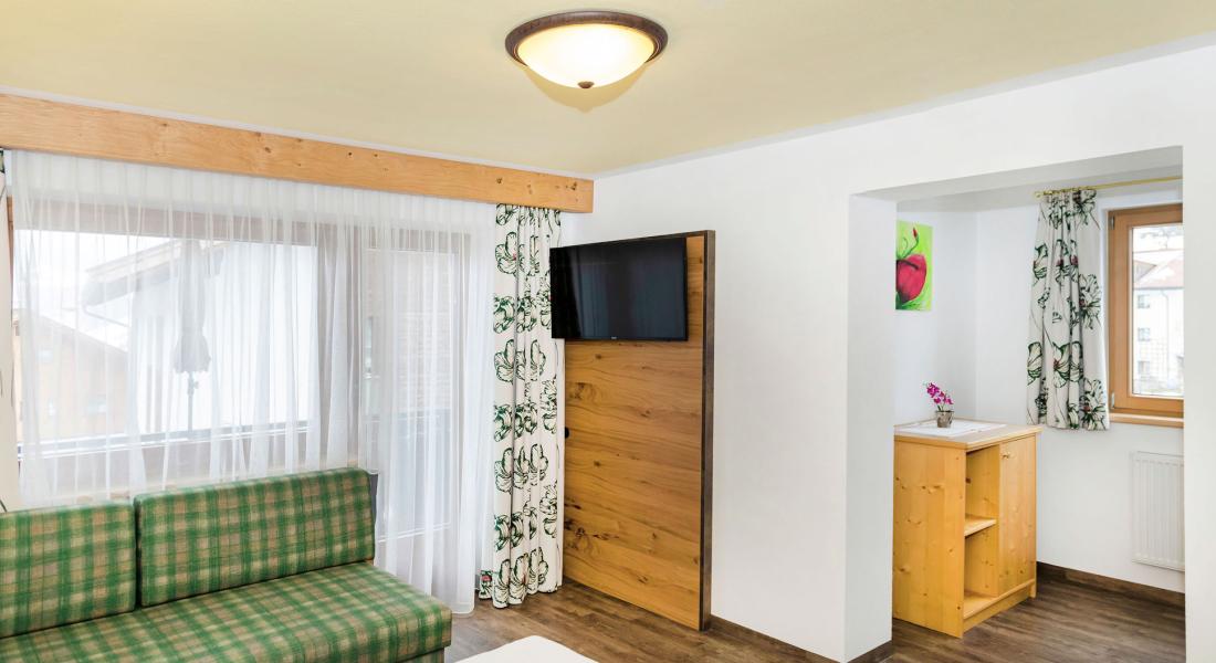 Wohn- und Schlafbereich im Komfortzimmer Deluxe Abendsonne im Landhotel Tirolerhof in Oberau in der Wildschönau mit Zugang zum Balkon